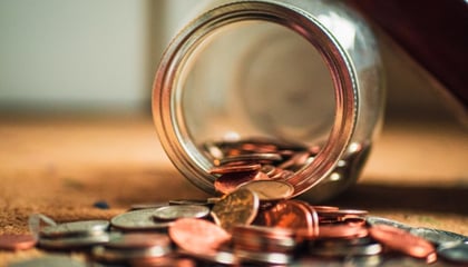 coins spilling out of jar 