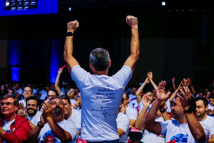 person with arms raised and crowd cheering